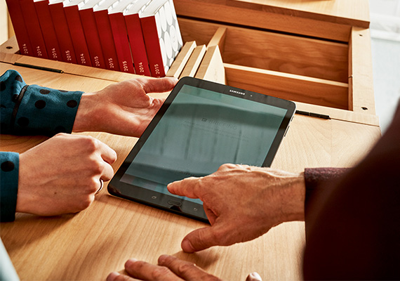 Aktivierung und Änderung von IoT Sim-Karten von Magenta Business Zwei Personen besprechen digitale Inhalte auf einem Samsung-Tablet an einem Holzschreibtisch