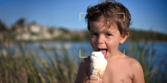 Ein Kind isst Eiscreme an einem Deich